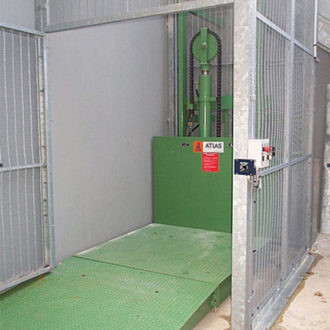 Monte-charge industriel: Vue intérieure de la cage avec porte ouverte et plateau élévateur en position basse.