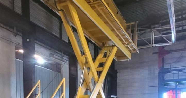Ciseaux et plancher d'une plateforme élévatrice jaune pour l'élévation de personnes