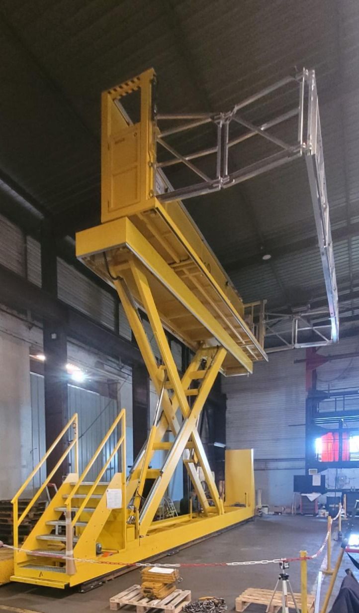 Plateforme élévatrice à ciseaux jaune avec escalier d'accès et garde-corps, pour l'élévation de personnes en hauteur