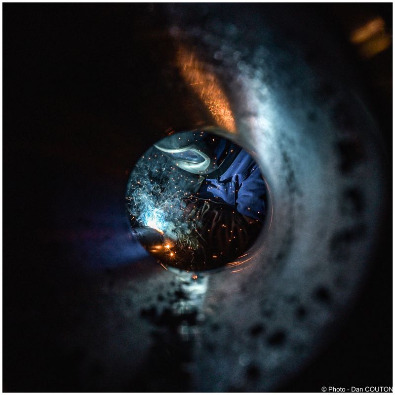 Soudeur au travail vu à travers un tube d'acier