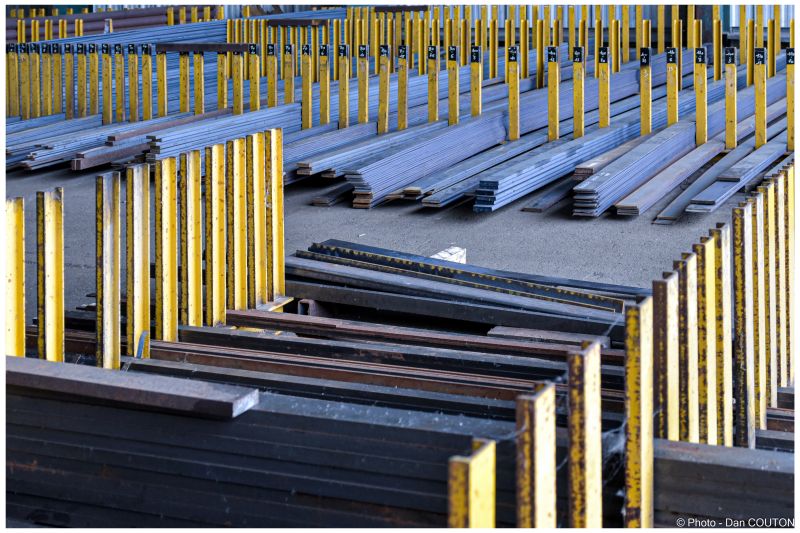 Stock de barres et de profilés en acier rangés dans des racks jaunes